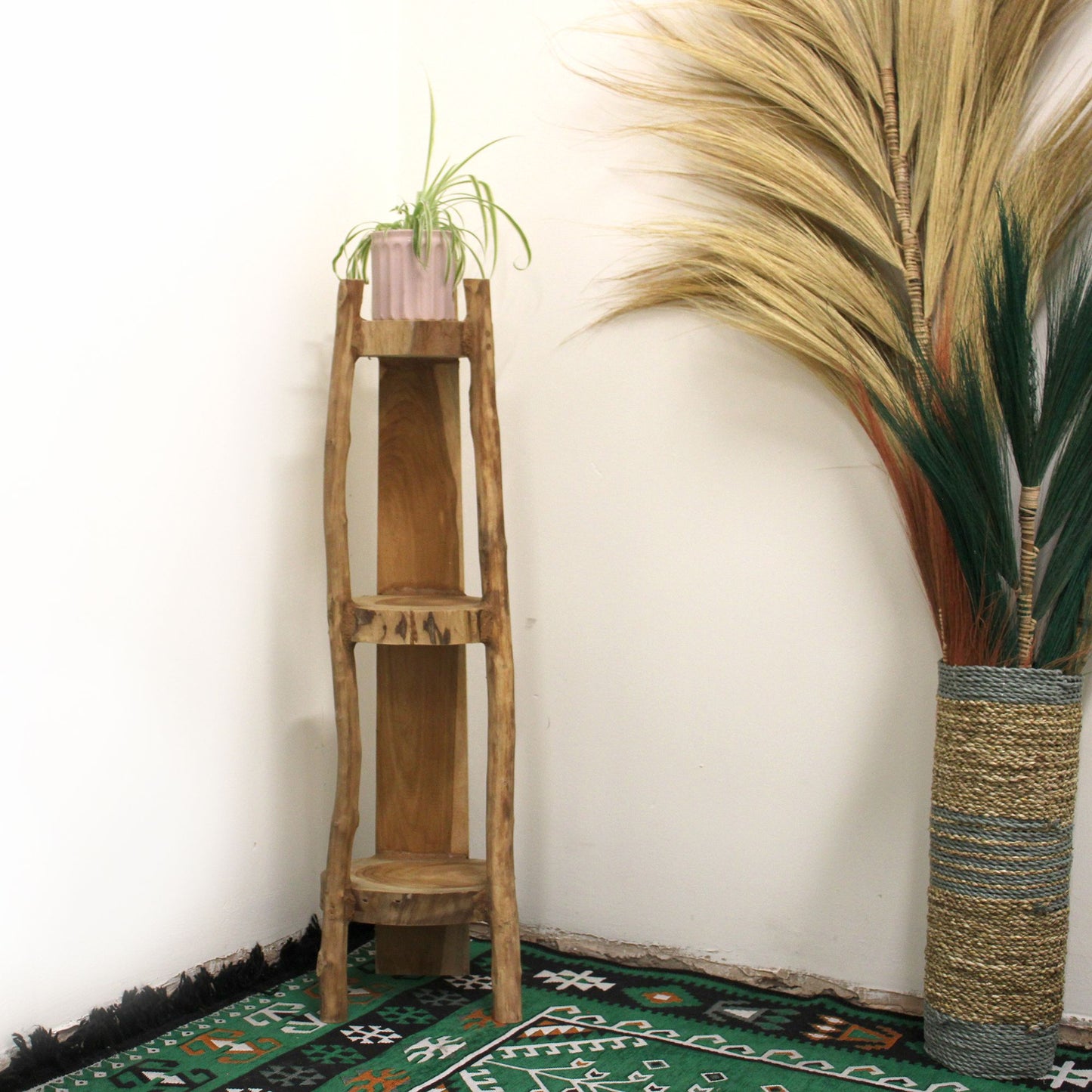 Natural teak corner unit with three shelves placed in a room corner