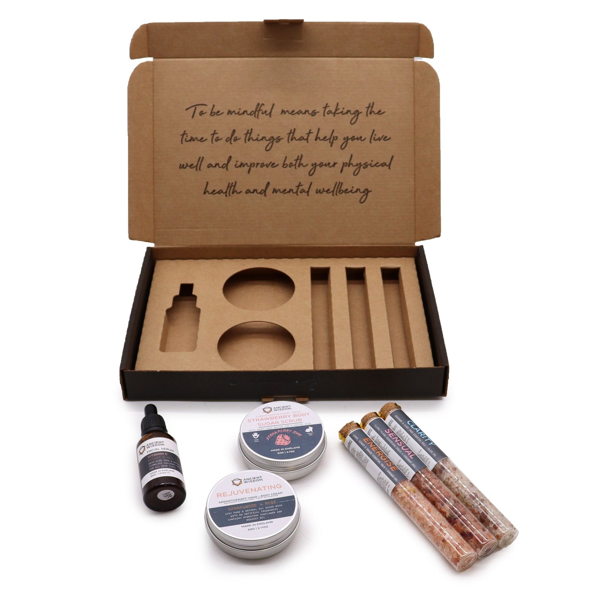 Self-care gift set in an open kraft box with body scrub, bath salts, oil and balm